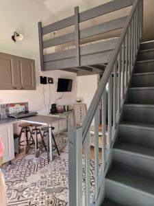 eine Treppe in einem Wohnzimmer mit einem Tisch und einer Küche in der Unterkunft le Cabanon de LEA in Tavel