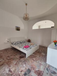 una camera bianca con un letto ad angolo di Borgo Di Taormina Apartments a Gaggi