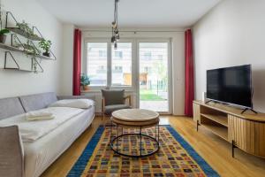 ein Wohnzimmer mit einem Sofa und einem TV in der Unterkunft Apartment with garden close to Stadthalle, Westbahnhof in Wien