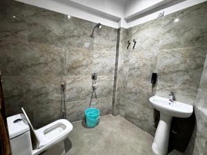 a bathroom with a shower and a sink and a toilet at Hotel Daharm in Lucknow