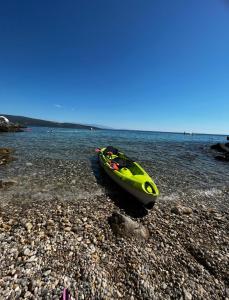 ein gelbes Kajak auf einem felsigen Strand in der Unterkunft LuxArt City Spa Gallery Residence Krk in Krk
