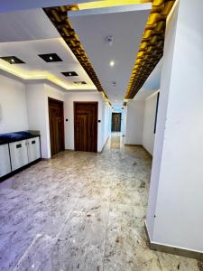 Habitación vacía con paredes blancas y suelo de mármol. en Hotel Daharm, en Lucknow