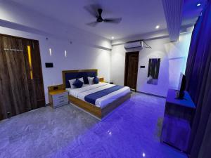 a bedroom with a bed and a tv in it at Hotel Daharm in Lucknow