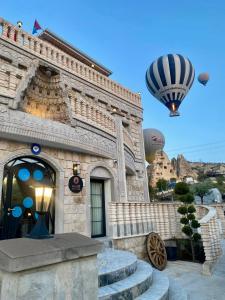 een heteluchtballon die over een gebouw vliegt bij Motif Art Cappadocia in Goreme