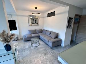 uma sala de estar com um sofá e uma mesa em MAGNIFIQUE T2 RÉSIDENCE LUXE MANDELIEU CANNES em Mandelieu-la-Napoule