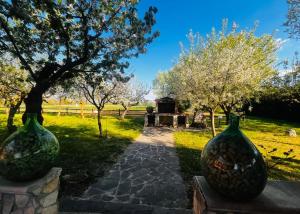 two large green vases sitting on a stone walkway with trees at B&B Sole e Luna in Scurcola Marsicana