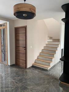 a hallway with a staircase and a wooden door at Maison Paray- Orly- Parking Privé in Paray-Vieille-Poste