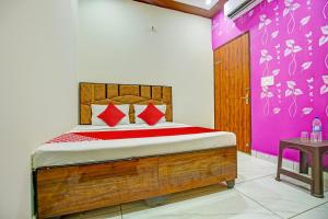 a bedroom with a bed and a purple wall at OYO Hotel Patiala in Kurukshetra