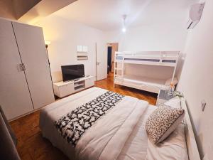 a bedroom with a bed and a tv in it at Peers Guest House in Cascais