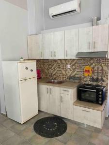 uma cozinha com um frigorífico branco e um micro-ondas em Zoe’s & Patty’s Guest House em Galaxidi