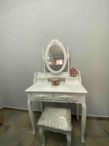 um toucador branco com um espelho e um banco em Zoe’s & Patty’s Guest House em Galaxidi