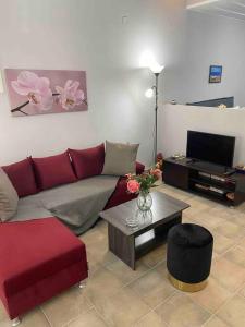 un soggiorno con divano rosso e tavolo di Zoe’s & Patty’s Guest House a Galaxidhion