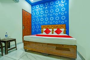 a bedroom with a bed with a blue wall at OYO Hotel Patiala in Kurukshetra