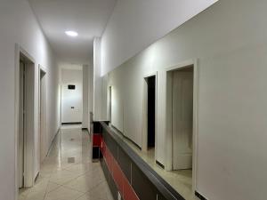 a hallway with white walls and a hallway with doors at Hotel Kristali in Peshkopi