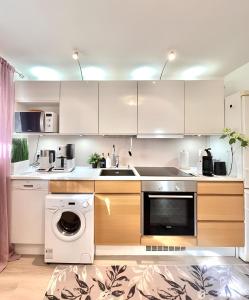 cocina con armarios blancos y lavavajillas en Helsinki Seaside Home with Free Parking, en Helsinki