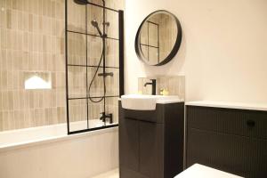 Un baño con lavabo y ducha con espejo. en Pass the Keys Apartment 3 Old Conservative Club in Historic Town, en Caernarfon