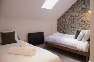 two beds in a room with a wall mural at Pass the Keys Apartment 3 Old Conservative Club in Historic Town in Caernarfon