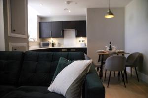 a living room with a couch and a kitchen at Pass the Keys Apartment 3 Old Conservative Club in Historic Town in Caernarfon