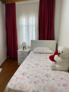 un osito de peluche blanco sentado en una cama en un dormitorio en Ayvalık'taki Eviniz en Ayvalık