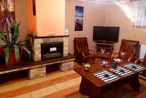 a living room with a fireplace and a tv at Noclegi Relax in Ruciane-Nida