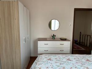 een slaapkamer met een bed, een dressoir en een spiegel bij Ayvalık'taki Eviniz in Ayvalık