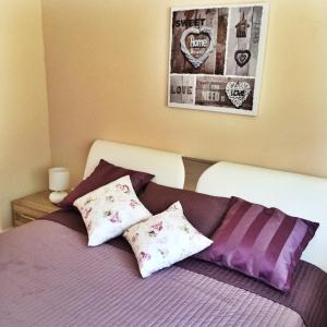 Un dormitorio con una cama con sábanas y almohadas púrpuras. en Sweet Apartments, en Baden-Baden