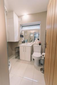 a bathroom with a white toilet and a sink at Modern Flat by the Underground. in London