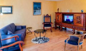 a living room with a blue couch and a tv at Appartement lumineux, 80m2, au calme, 10mn à pieds de la plage in Les Sables-dʼOlonne