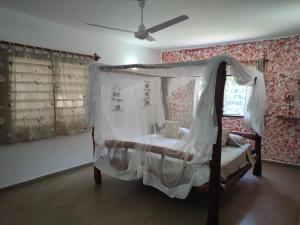 a bedroom with a canopy bed and a window at Malaica in Kilifi