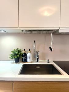 um lavatório de cozinha com duas garrafas em Helsinki Seaside Home with Free Parking em Helsinque