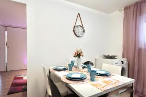 a dining room table with a clock on the wall at Helsinki Seaside Home with Free Parking in Helsinki