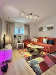 uma sala de estar com um sofá vermelho e uma mesa em Helsinki Seaside Home with Free Parking em Helsinque