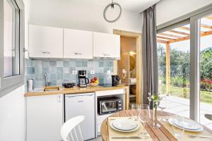 a kitchen with white cabinets and a wooden table at Kumquart estate- Kumquat in Aspiotádes