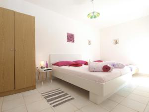 ein Schlafzimmer mit einem großen weißen Bett mit rosa Kissen in der Unterkunft Studio für 6 Personen ca 50 qm in Banjole, Istrien Istrische Riviera in Banjole