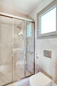 uma casa de banho com uma cabina de duche em vidro e um WC. em Kumquart estate- Kumquat em Aspiotádes