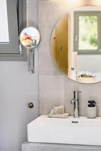 a bathroom with a sink and a mirror at Kumquart estate- Kumquat in Aspiotádes