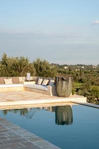 einen Pool mit einem Sofa und einem Tisch in der Unterkunft Trullo Saraceno in Ostuni