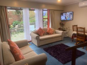 a living room with two couches and a table at Sunny holiday home Wellington in Wellington