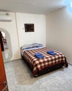 a bedroom with a bed with two blue towels on it at Clotilde Depto Completo in Posadas