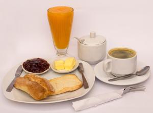 a plate of breakfast food with a drink and coffee at Casa Hospedaje el Prado Eco turismo in Oxapampa