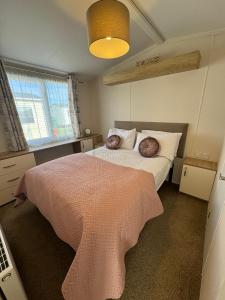1 dormitorio con 1 cama con 2 almohadas en Golden Palm Resort - The Twilight - Coastal Caravan Breaks, en Chapel St. Leonards
