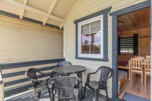 a patio with a table and chairs on a porch at Domek 5 osobowy in Stegna