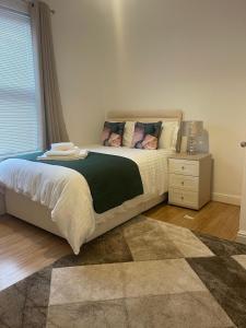 a bedroom with a large bed with a night stand at Robinhuts Stays - 3 Bed property Perfect for contractors and families in Hull