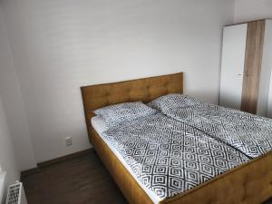uma cama com uma cabeceira em madeira num quarto em Apartmán Topoľčany em Topoľčany
