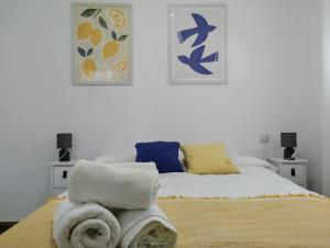 a bedroom with a bed with towels on it at Apartamento Puertomar in El Puerto de Santa María