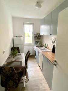 een keuken met witte kasten en een tafel en een raam bij Komplette Wohnung nahe am See in Prenzlau