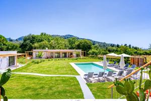 a backyard with a pool and chairs and a house at Kumquart estate- Kumquat in Aspiotádes