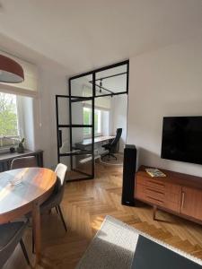 - un salon avec une table et un grand miroir dans l'établissement Joli Apartment, à Varsovie