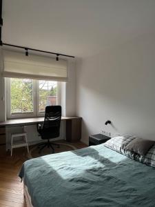 - une chambre avec un lit, un bureau et une chaise dans l'établissement Joli Apartment, à Varsovie