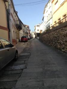 Une allée avec des voitures garées sur le côté d'un bâtiment dans l'établissement Sobre la villa 12, à Neda